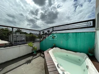 Vista da varanda com banheira de hidromassagem e muro verde em Lajeado.