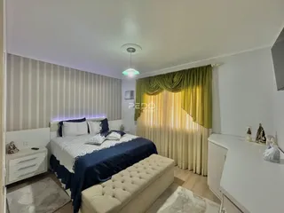 Quarto com cama e cortinas em ambiente claro.