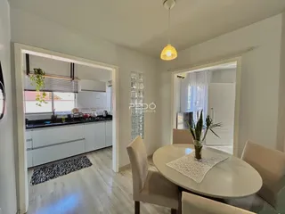 Sala de estar com mesa de jantar e vista para a cozinha em Lajeado.