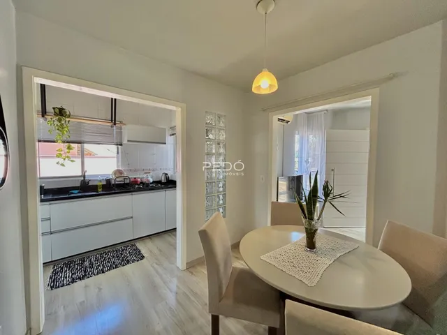 Sala de estar com mesa de jantar e vista para a cozinha em Lajeado.