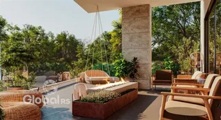 Área externa com mobiliário de jardim e plantas.