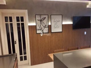 Sala de estar com portas brancas e painel de madeira na parede.