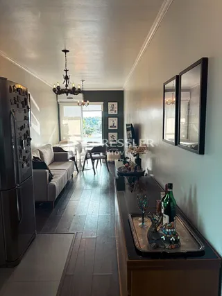 Sala de estar com piso de madeira e luz natural entrando pela janela.