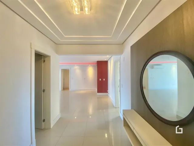 Hall de entrada com piso claro e paredes brancas.