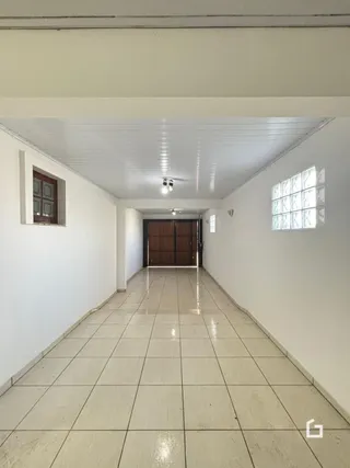 A foto mostra um corredor interno de uma residência com piso de cerâmica.
