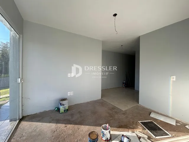 Interior de uma sala vazia com piso de concreto no imóvel em Lajeado.