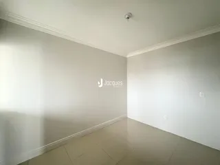 Vista interna de um corredor com paredes brancas e piso claro.