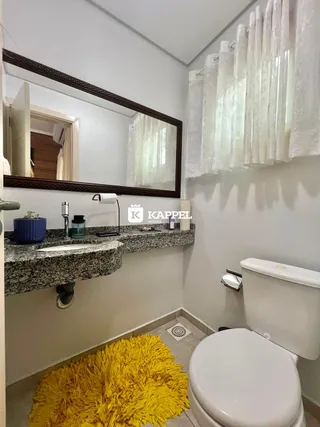 Banheiro com bancada de granito e vaso sanitário branco.