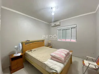 Quarto com cama de madeira e janela com persianas.