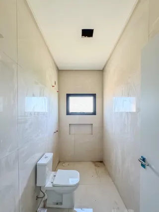 Corredor interno com paredes brancas e piso claro.