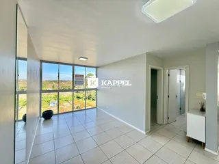 Sala ampla com piso de cerâmica e vista para a paisagem externa.