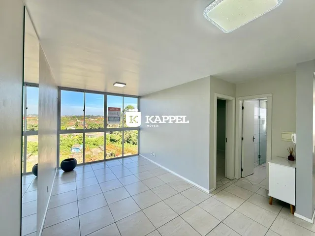 Sala ampla com piso de cerâmica e vista para a paisagem externa.