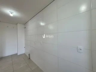 Parede interna com revestimento cerâmico branco em um corredor.
