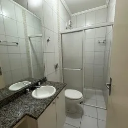 Foto de um banheiro com revestimento de azulejos brancos.