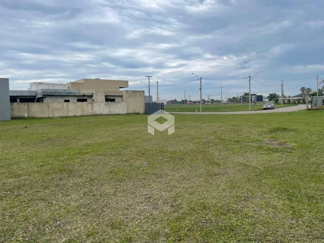 Campo gramado com uma parede de concreto ao fundo.