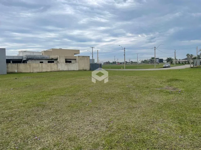 Campo gramado com uma parede de concreto ao fundo.