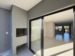 Vista de um corredor interno com portas de vidro em uma residência.