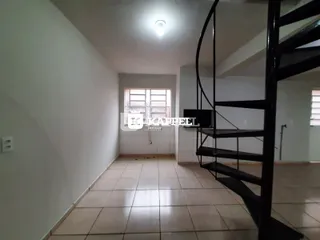 Hall de entrada com piso de cerâmica e escada preta em um apartamento.