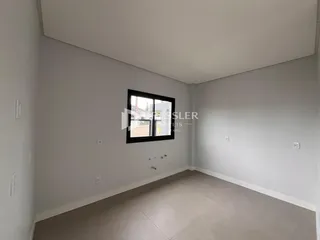 Foto de um cômodo vazio com paredes brancas e piso claro.