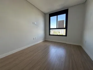 Foto de um cômodo com piso de madeira e grande janela.