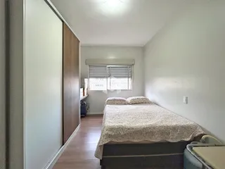 Quarto com cama e porta de madeira em um imóvel no Brasil.