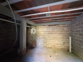 Parede de tijolo exposta em uma área interna com estrutura de concreto.