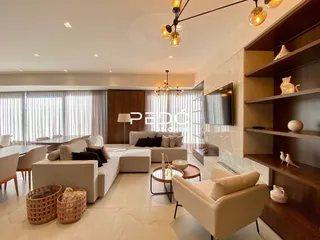 Sala de estar moderna com grandes janelas e decoração contemporânea.