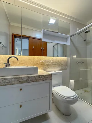 Foto de um banheiro moderno com bancada e box de vidro.