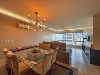 Sala de estar com sofá e mesa de jantar em um apartamento.