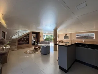 Sala de estar ampla com piso claro e detalhes em madeira.
