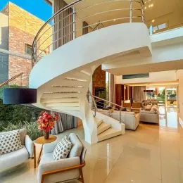 Sala de estar com arquitetura moderna e teto curvo em um imóvel em Lajeado.