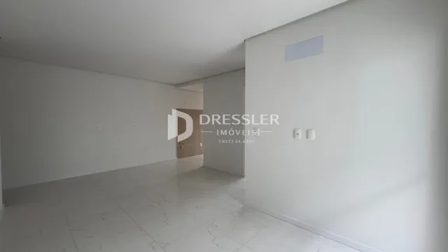 Corredor interno de uma residência com piso claro.