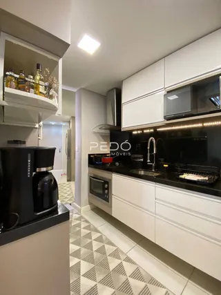 Vista da cozinha moderna com armários brancos e piso em padrão geométrico.