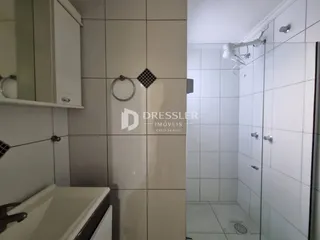 Foto de um banheiro com revestimento de azulejos e box de vidro.