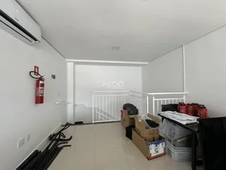 Vista interna de um corredor com paredes brancas e piso claro.