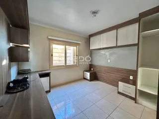 Ambiente interno de uma sala com piso de cerâmica e armários em madeira.