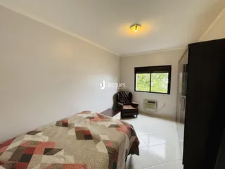Quarto com cama e poltrona em ambiente claro.