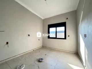 Foto de um cômodo interno com paredes brancas e uma janela grande.