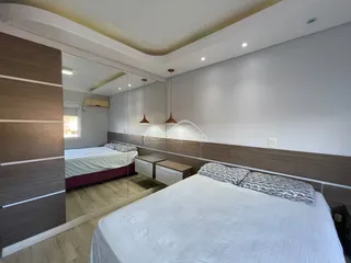 Quarto com cama grande e painéis de madeira.