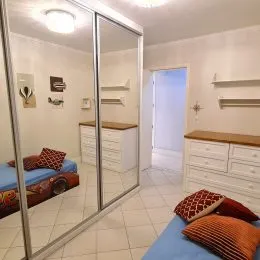 Um corredor interno com piso de cerâmica e espelhos.
