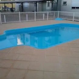 Foto de uma piscina azul em uma área externa de imóvel.