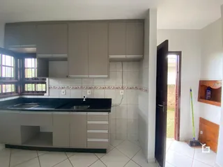 Vista da cozinha com armários e revestimento de azulejos em Lajeado.
