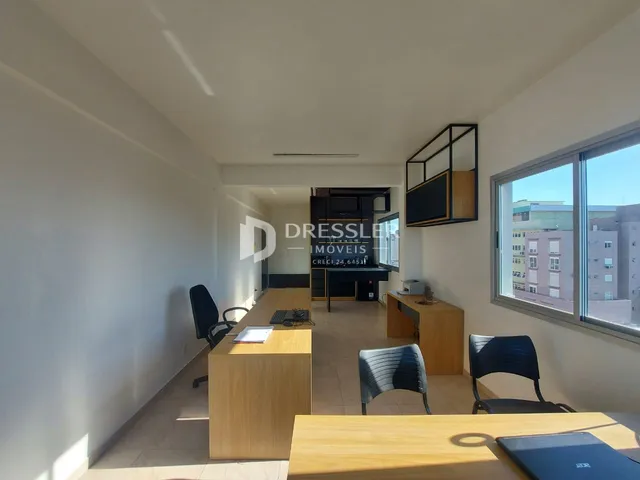 Interior de um espaço aberto com mesa de trabalho e janela em Lajeado.
