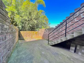 Vista externa de um pátio com paredes de tijolo e escadarias em Lajeado.
