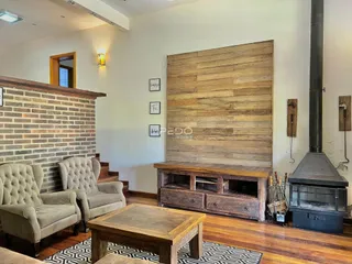 Sala de estar com paredes de tijolo e piso de madeira.