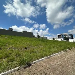Vista externa de um terreno gramado com céu azul.