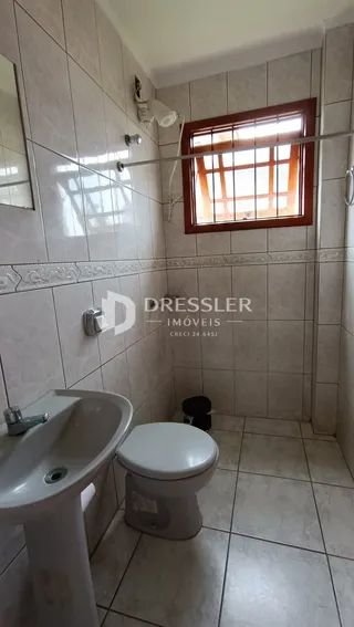 Foto de um banheiro com azulejos brancos e louças sanitárias.