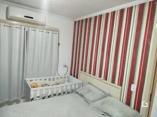 Foto de um quarto com cama de madeira e cortinas brancas.