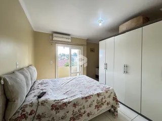 Quarto com cama e armário branco.