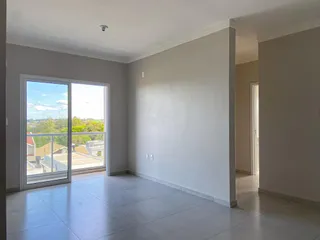 Sala de estar com grande janela que oferece vista da paisagem urbana.